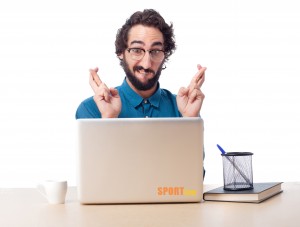 businessman cross fingers with laptop
